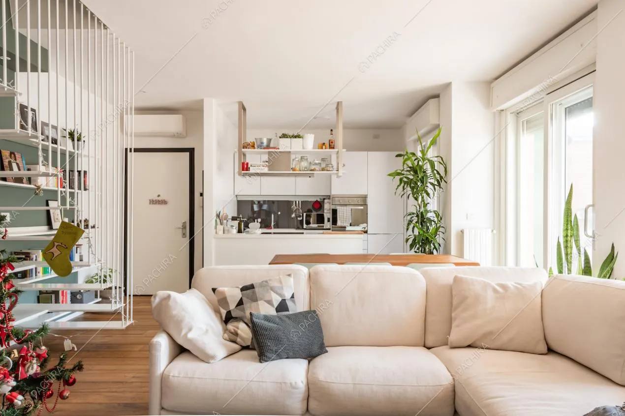 Divano bianco al centro della zona giorno e parquet