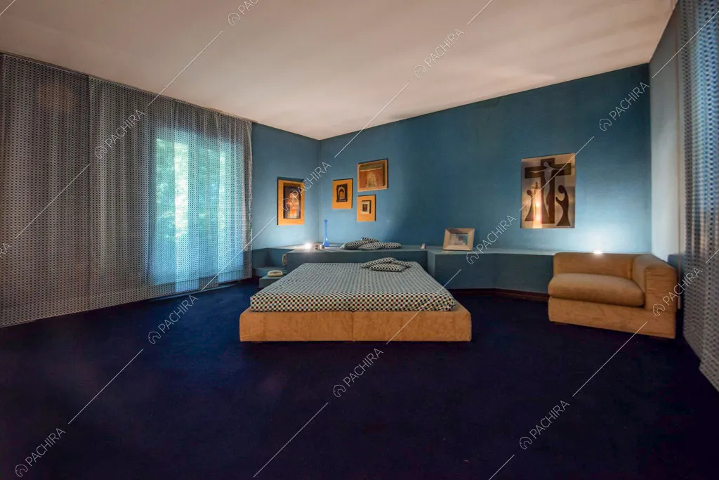 Grande camera da letto matrimoniale con pavimento in moquette blu e pareti azzurre