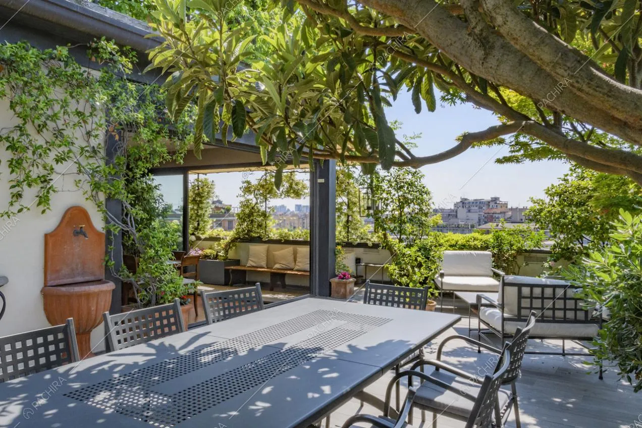 Dettaglio del tavolo da pranzo sotto alle piante del terrazzo
