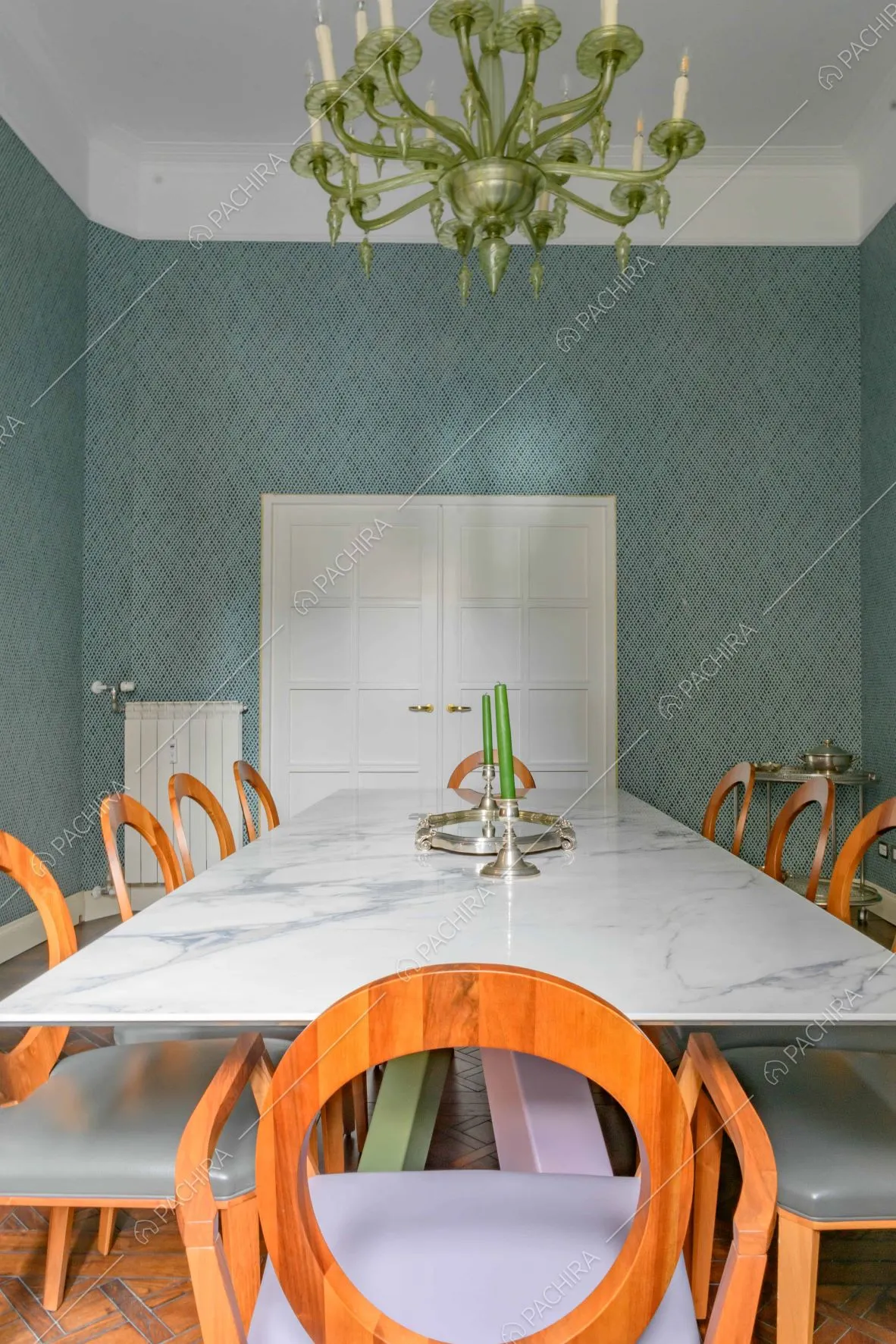 Sala da pranzo con tavolo in marmo, lampadario verde antico e boiserie sul soffitto