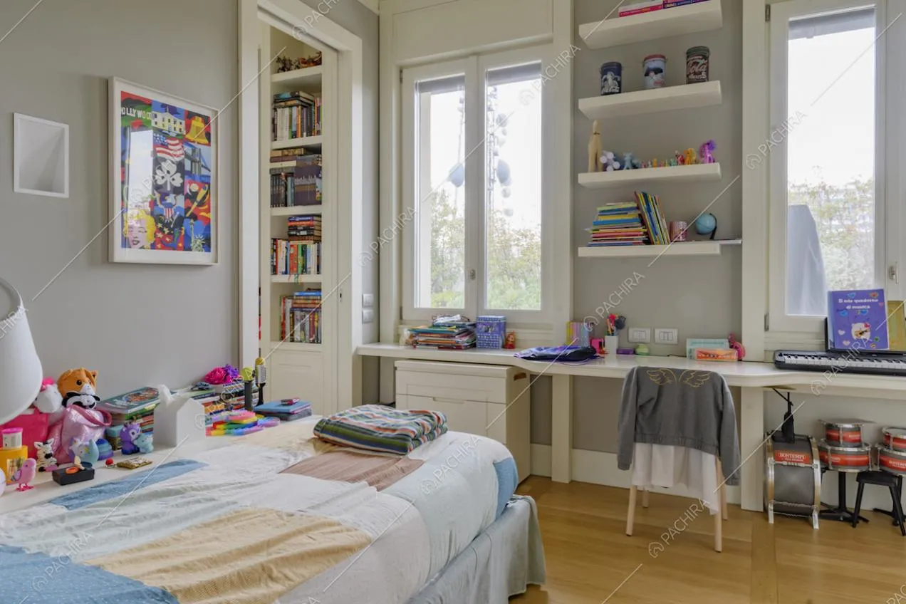 Camera da letto da bambini con pavimento in parquet, lunga scrivania e finestre dagli infissi bianchi