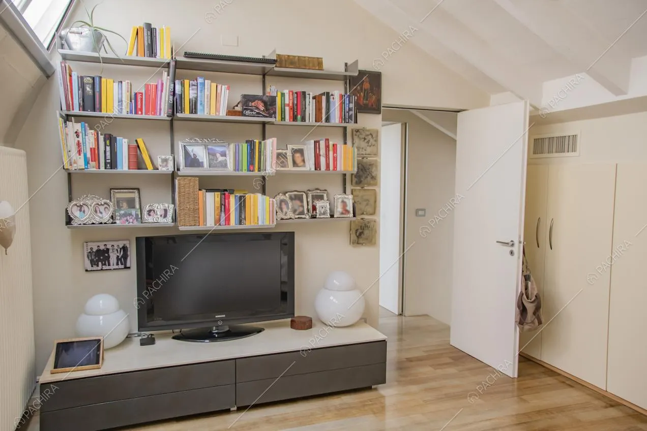 Mensole con libri e portafoto, televisione su mobile basso