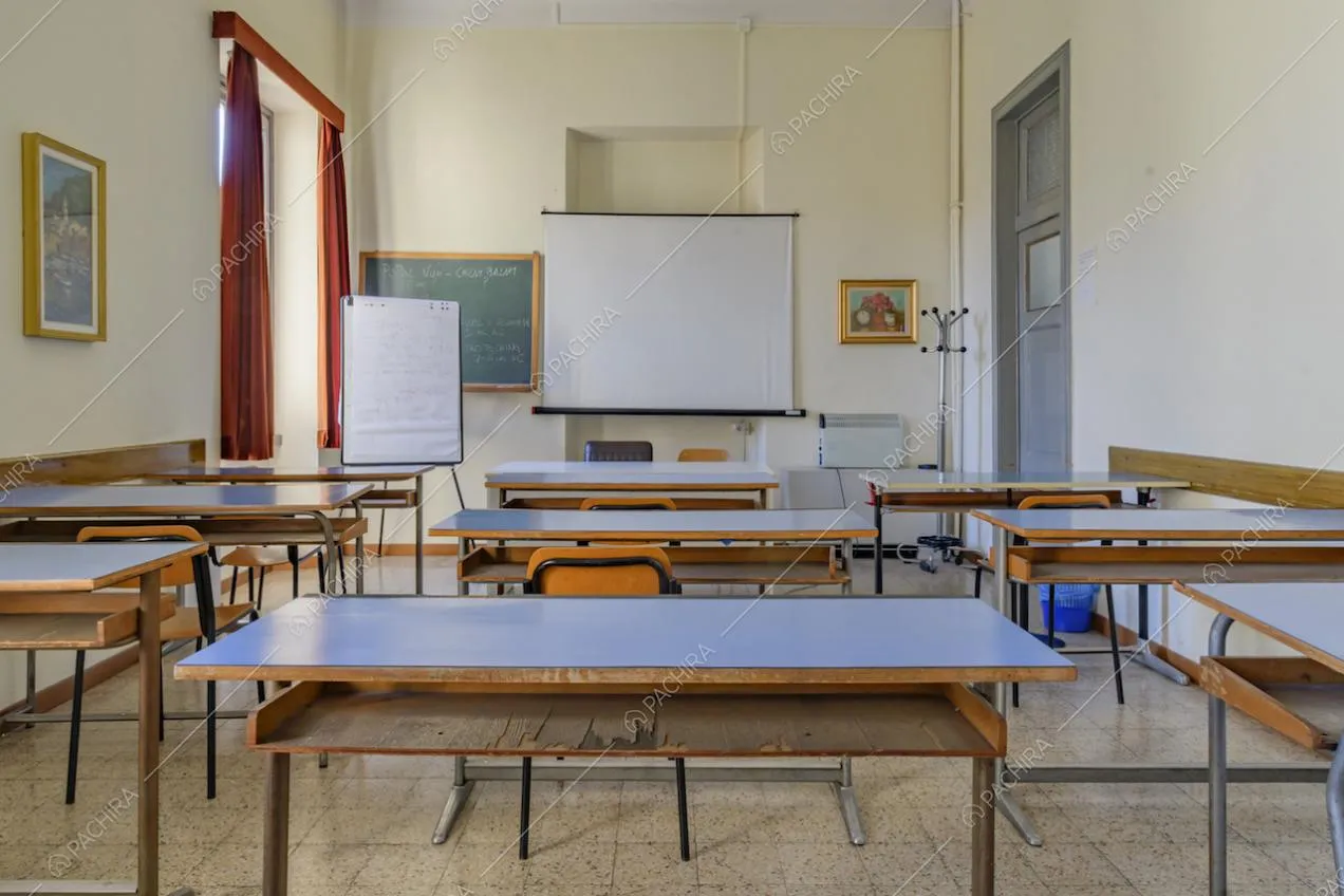 Ampia aula con banchi in legno, finestra con tende rosse e tre lavagne