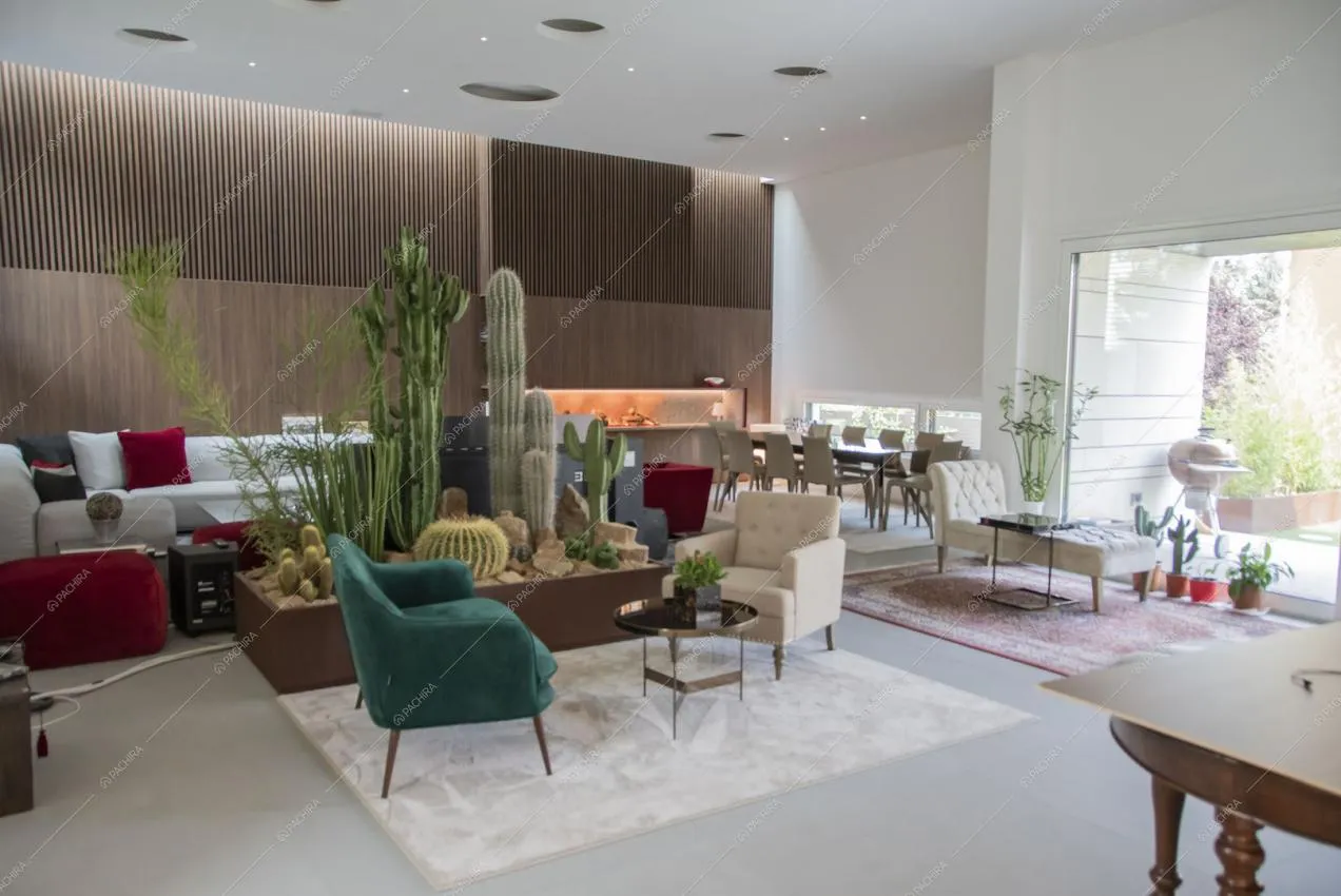 Ampia zona living con poltrone di varie tipologie e vetrata con vista sul giardino