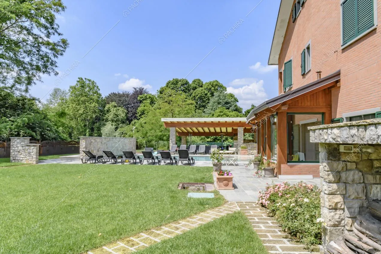 Camino esterno in pietra, nel giardino privato della location, vista sugli esterni in cotto e su veranda e pergolato