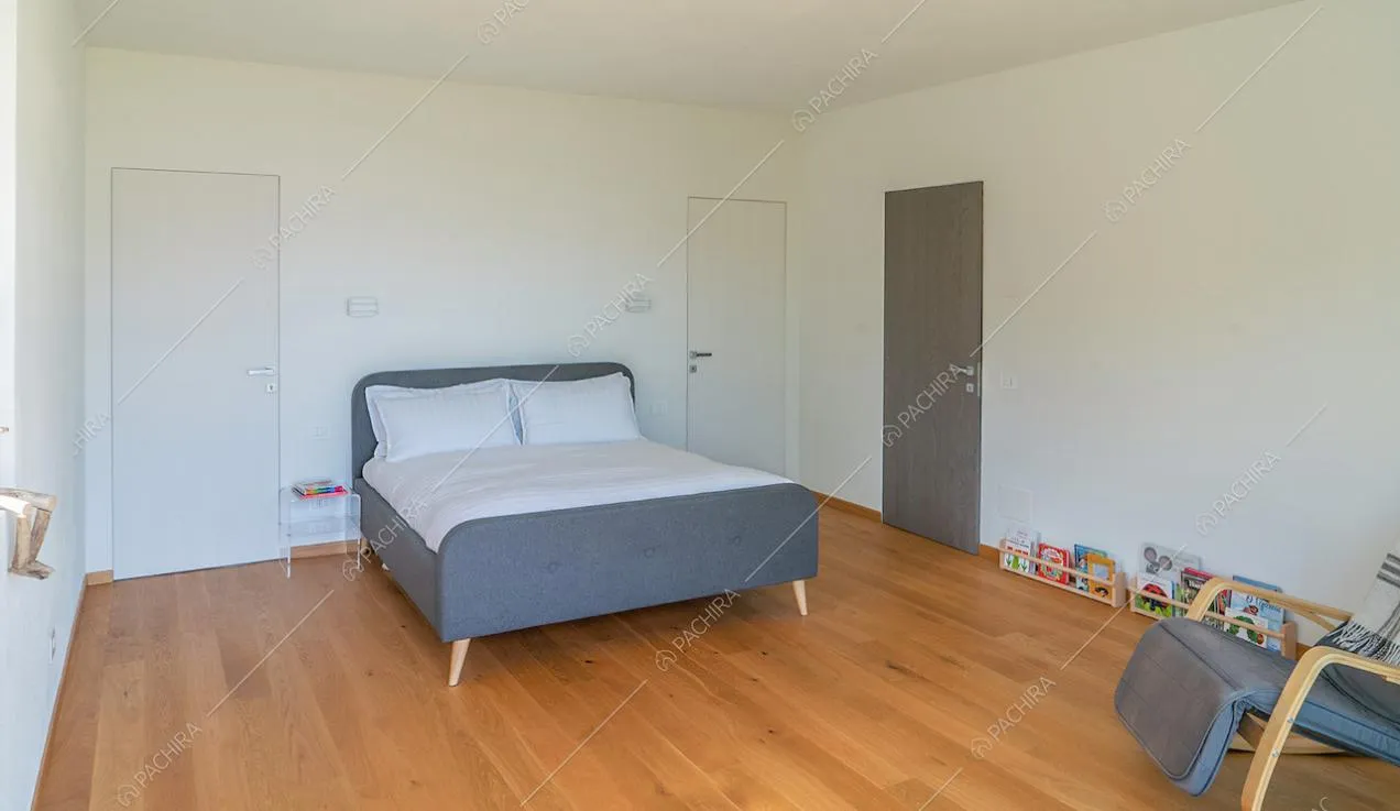 Luminosa camera da letto matrimoniale con pavimento in parquet e pareti bianche