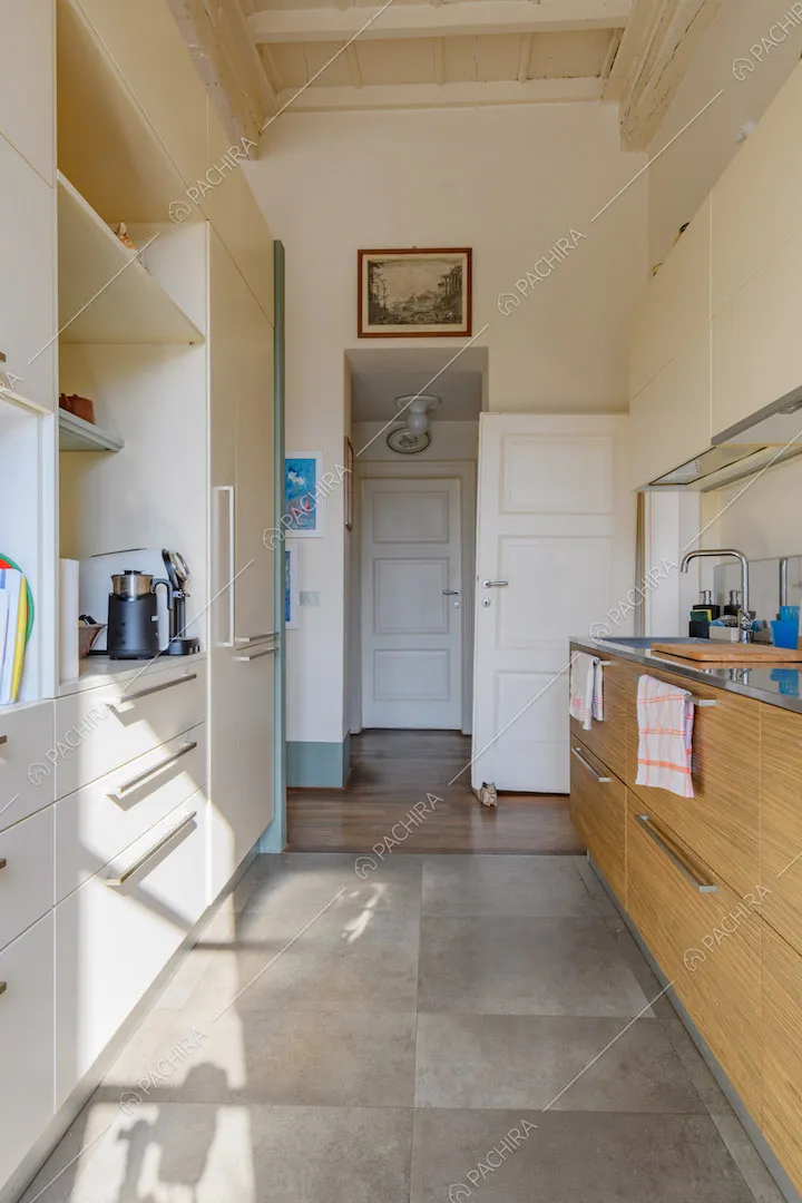 Pavimento in grandi piastrelle grigie nella cucina a parete con soffitto bianco a cassettoni
