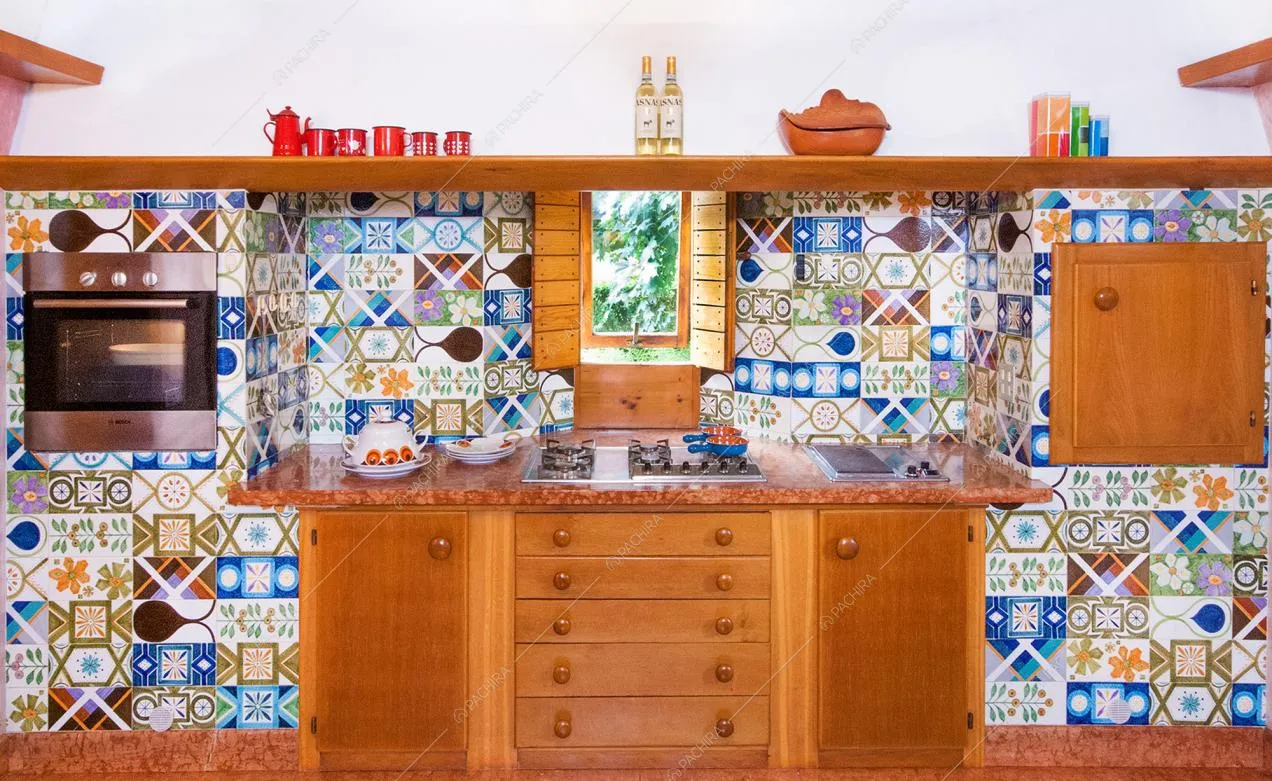 Cucina in legno e parete rivestita con cementine colorate