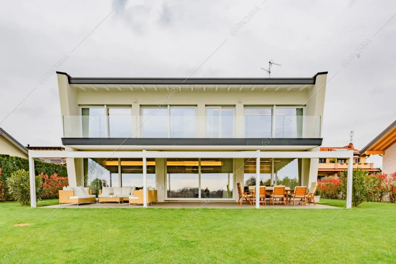Dal giardino vista sulla villa con terrazza, veranda e grandi vetrate