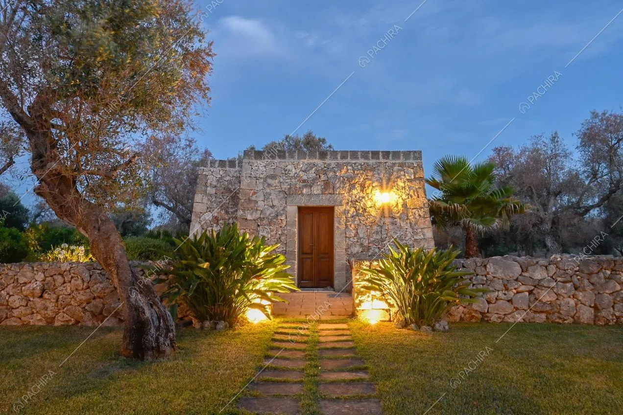 Nel giardino, vialetto di accesso a un trullo, adibito a unità indipendente dalla villa