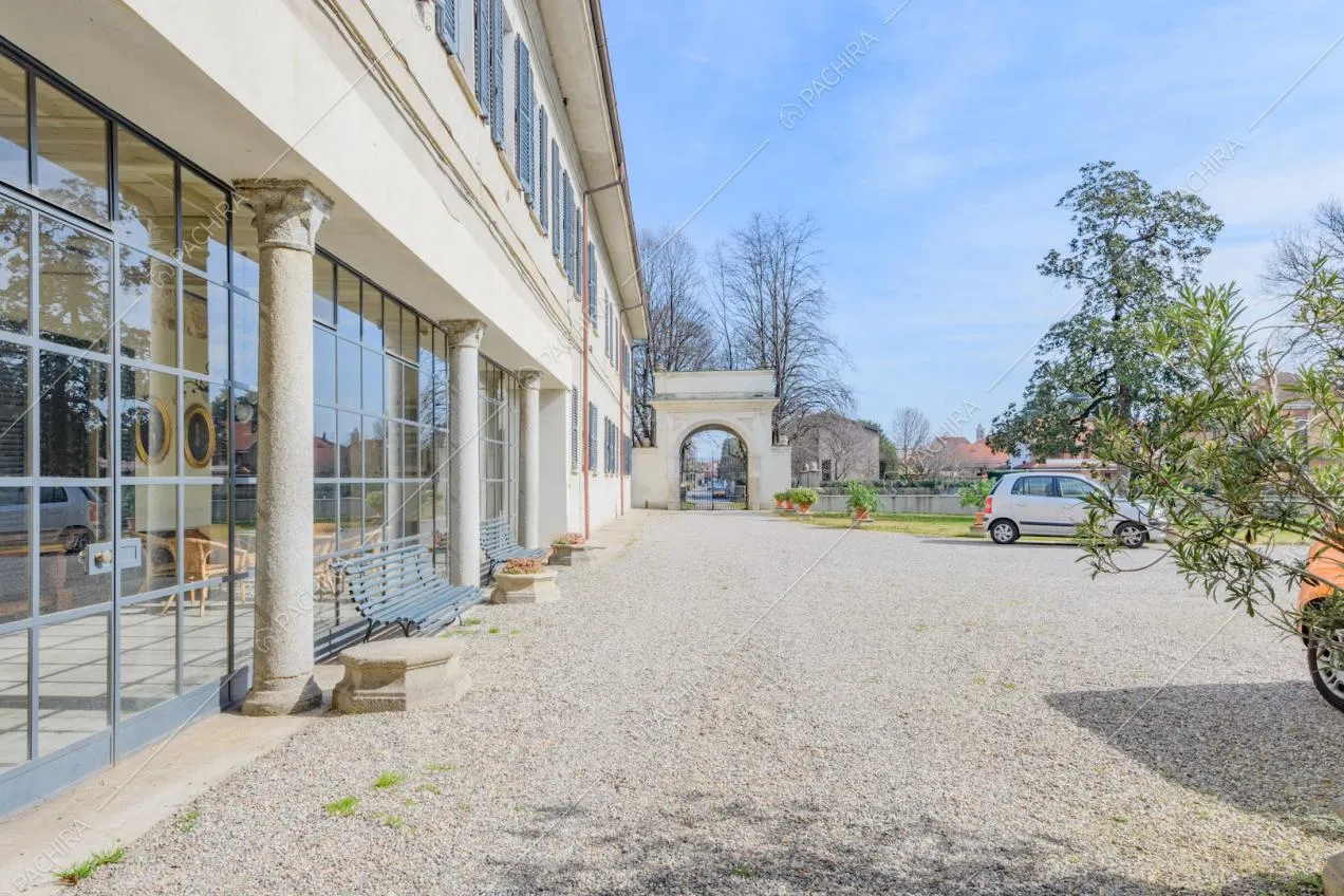 Dal cortile con pavimentazione in ciottoli vista sulle finestre in stile industriale della veranda