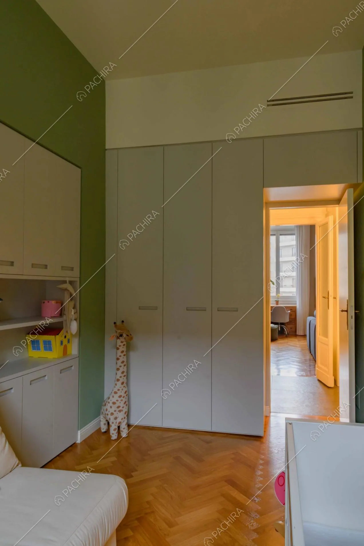 Dalla camera da letto da bambini con pareti verdi vista sul soggiorno