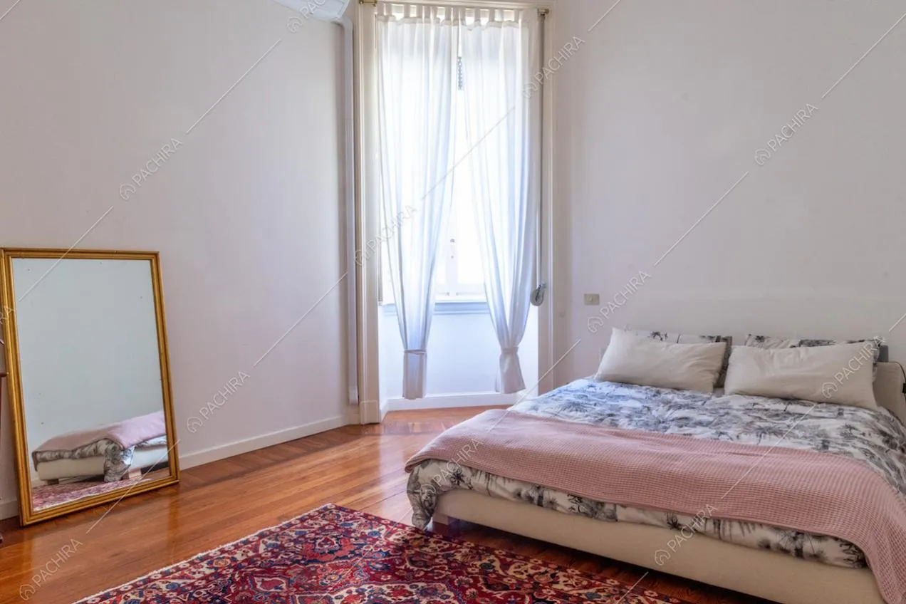 Camera da letto matrimoniale con pavimento in parquet e pareti bianche