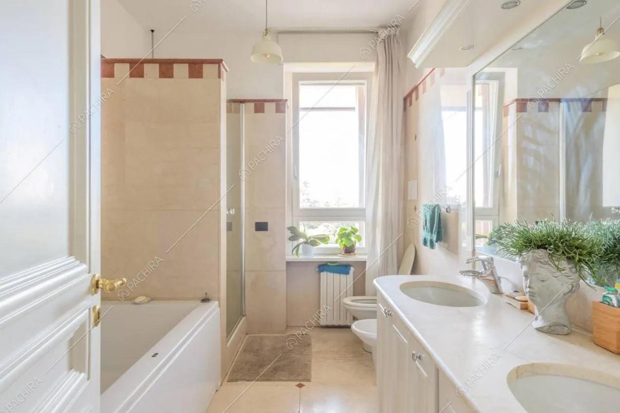 Ampio bagno con vasca, pavimento in marmo e doppio lavandino