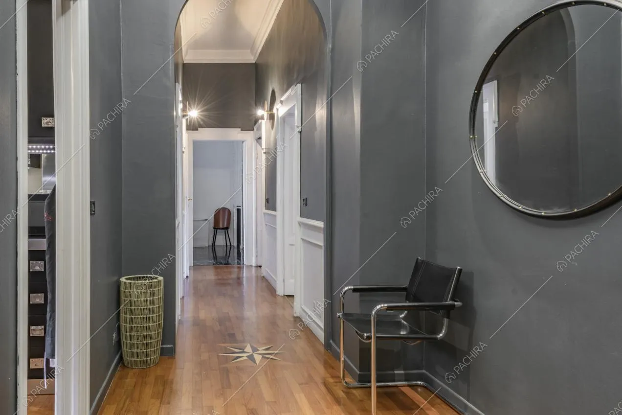 Specchio tondo su parete color grigio scuro e sedia di design