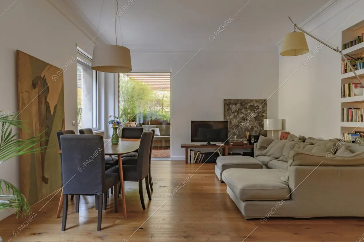 Dalla sala con tavolo e divano angolare grigio, vista sulla terrazza con veranda