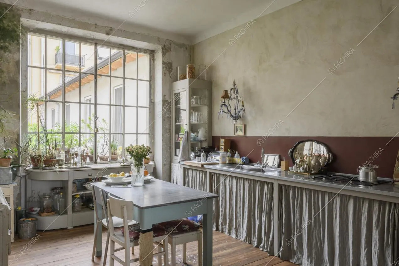 Cucina con mobili chiari e pareti con effetto délabré