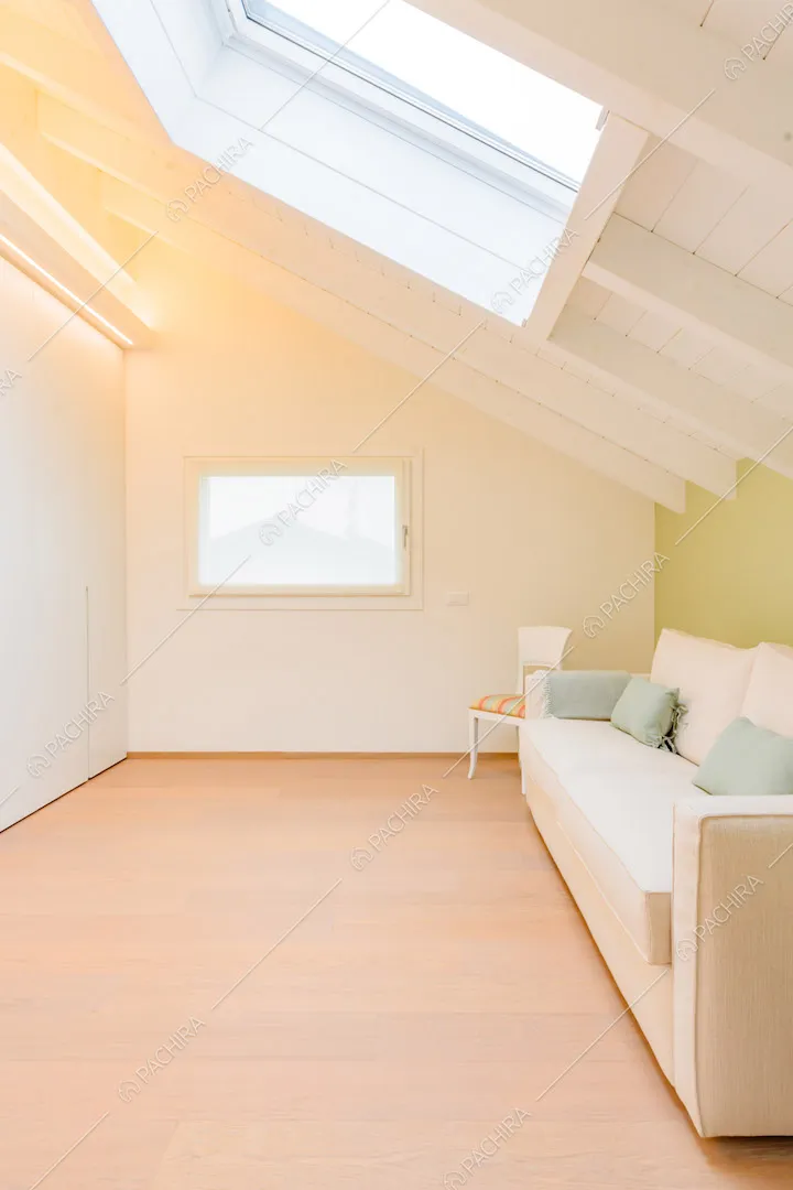 Pavimento in parquet, divano bianco e parete verde sul solaio con lucernario
