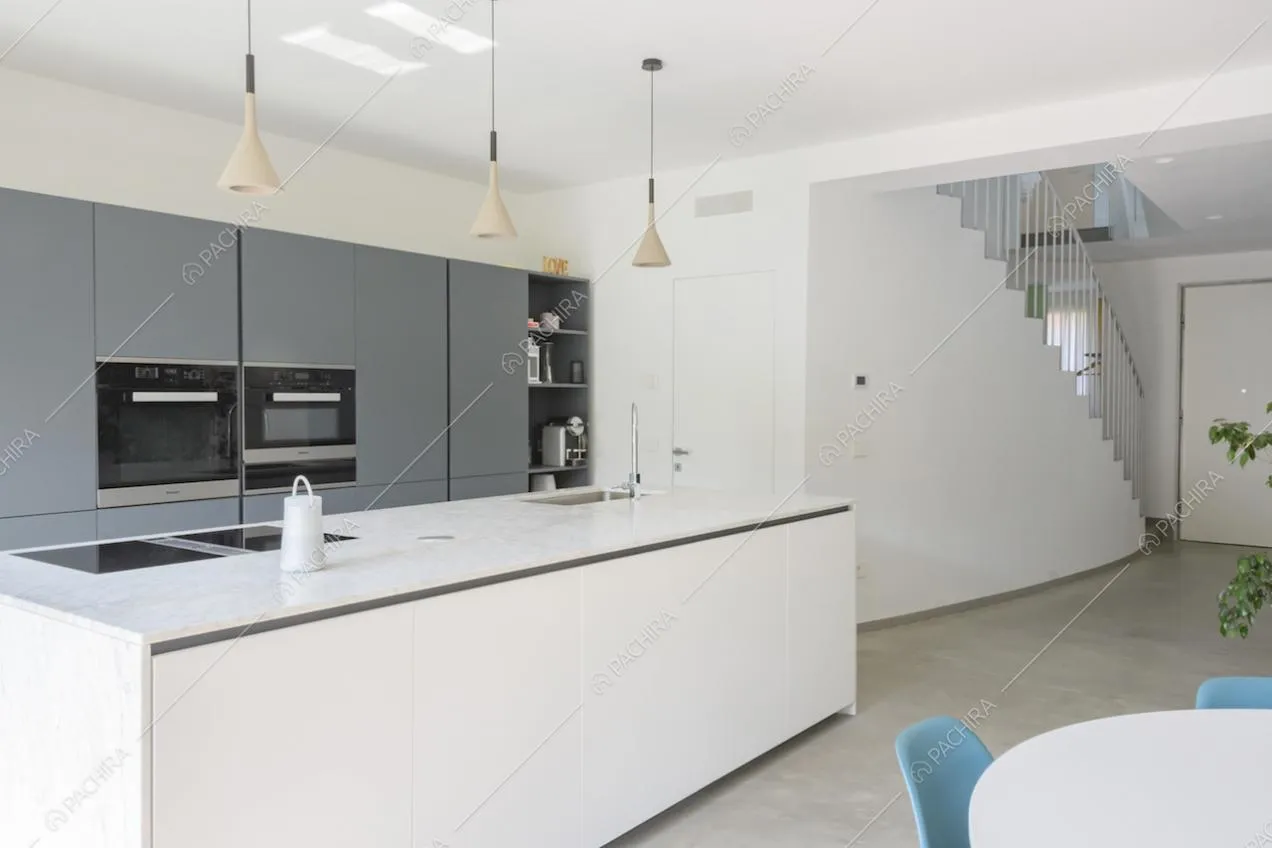 Cucina grigia e bianca con elettrodomestici e fornelli a induzione
