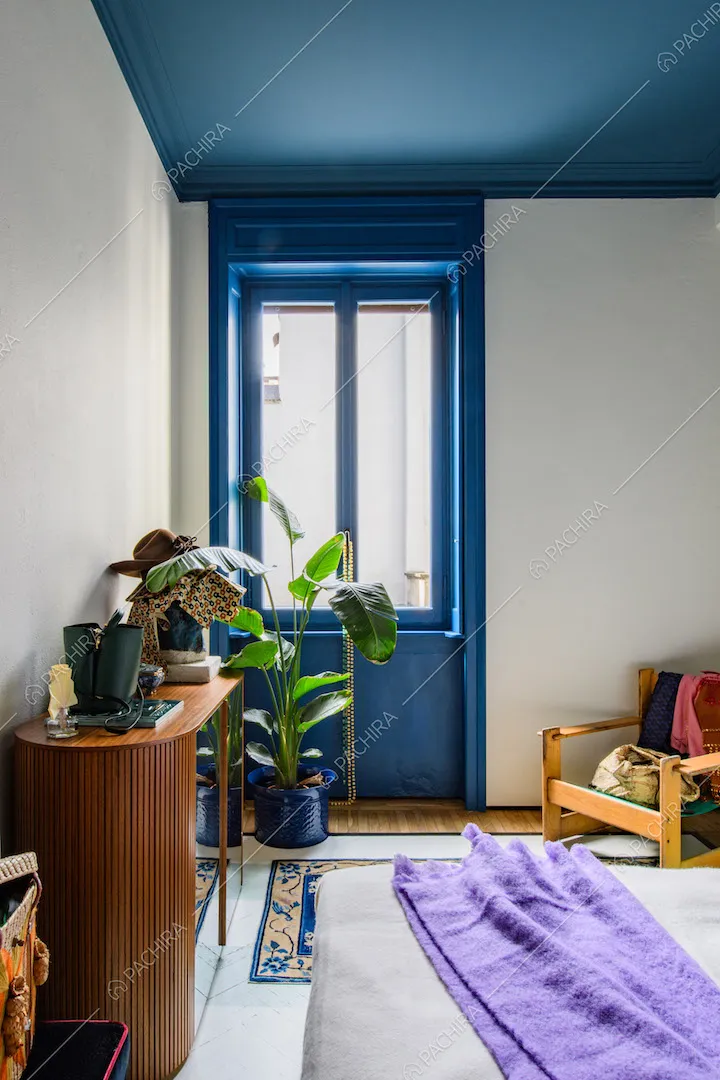 Porta-finestra e soffitto blu nella camera da letto matrimoniale con pavimento in parquet