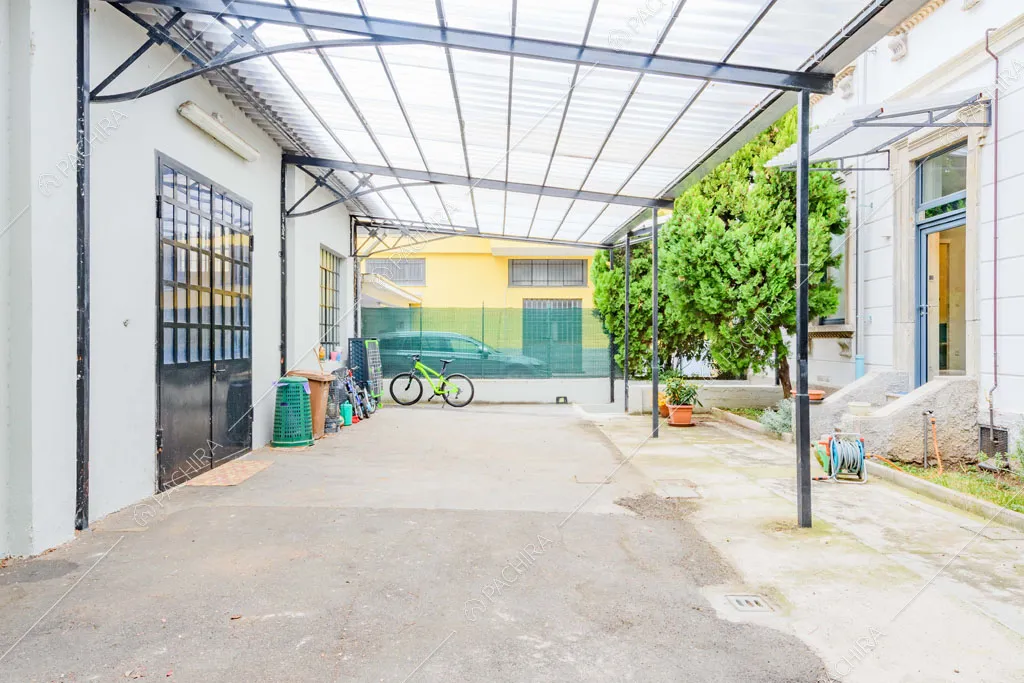 Ampia tettoia nel cortile con vista sugli esterni e sulla porta in stile industriale