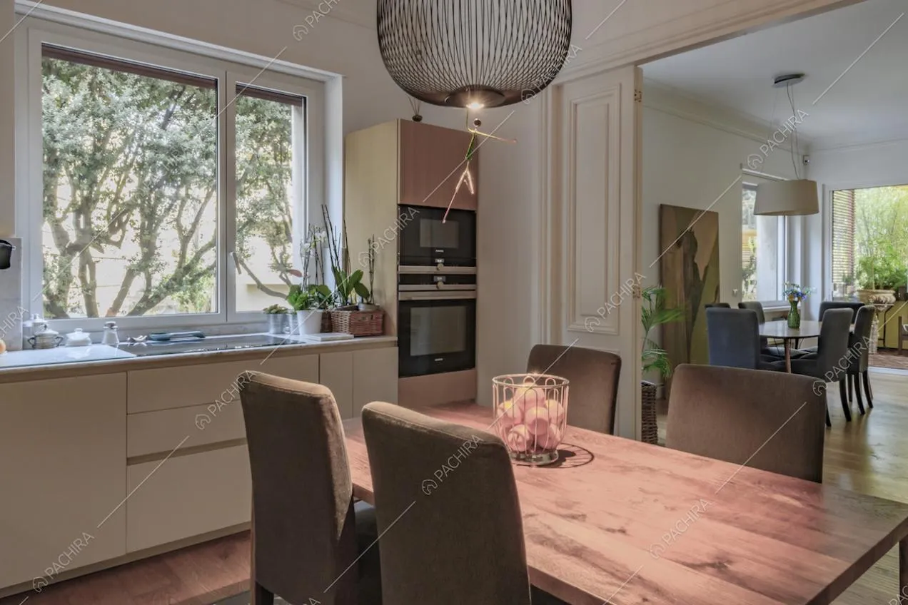 Dalla cucina con fornelli a induzione e tavolo da pranzo vista sulla sala