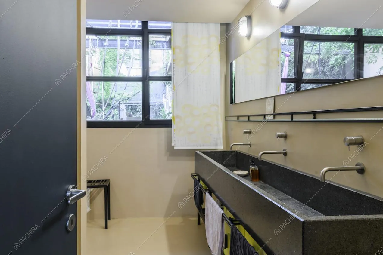 Bagno moderno con pareti bianche e finestra dalle rifiniture nere