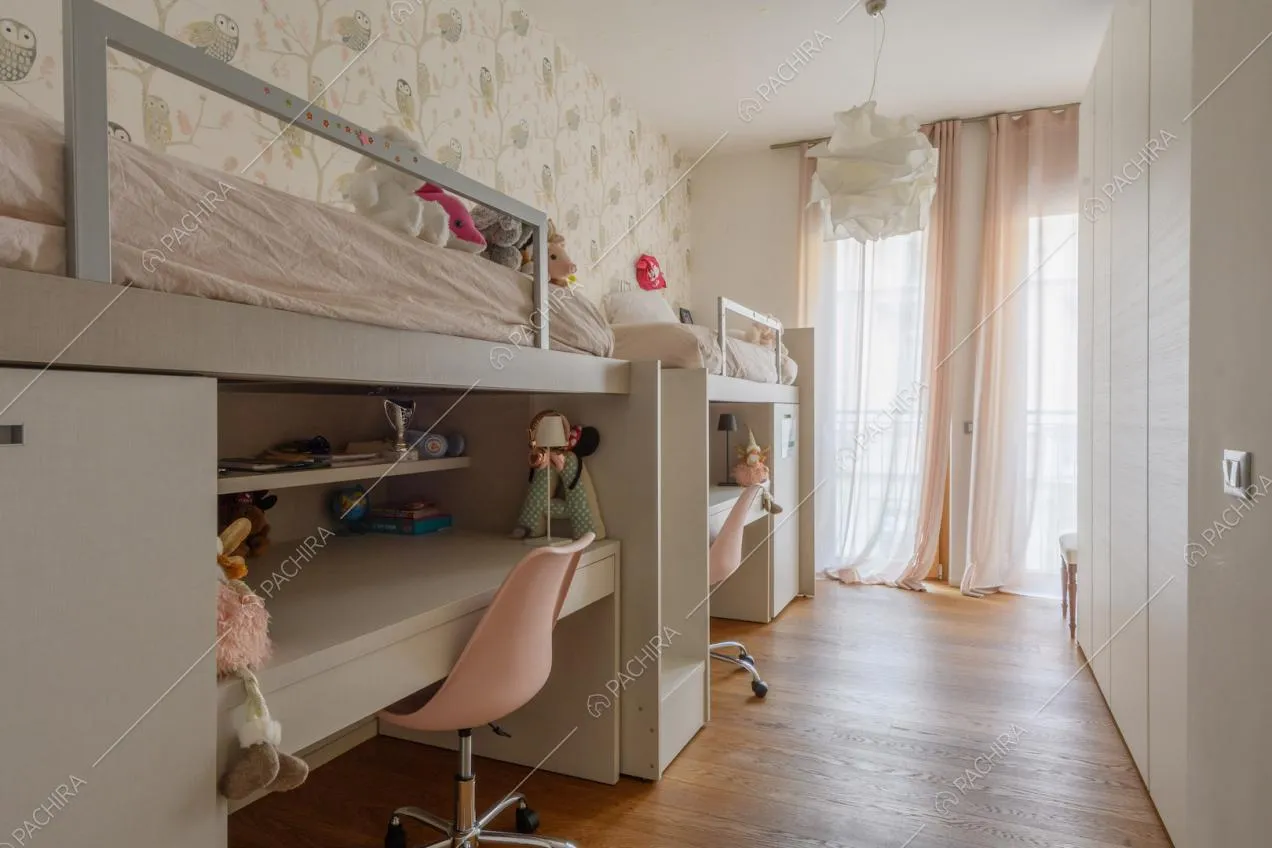 Camera dei bambini con due letti, due scrivanie e pavimento in parquet