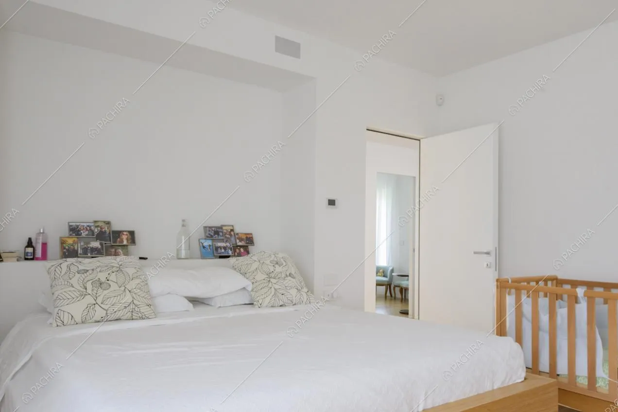 Camera matrimoniale con letto e culla con sbarre in legno