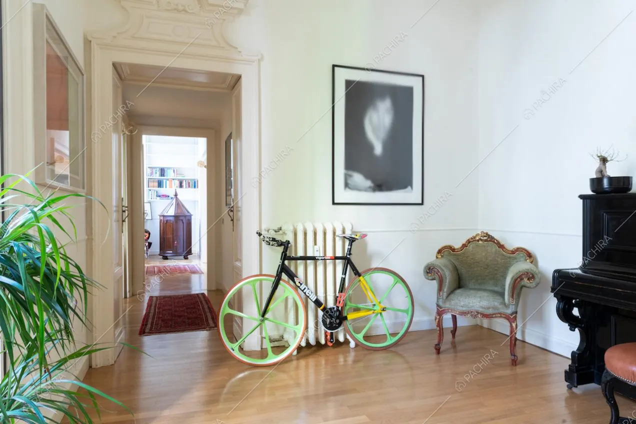 Atrio dalle pareti bianche con pavimento in parquet, corridoio e vista sulla camera da letto