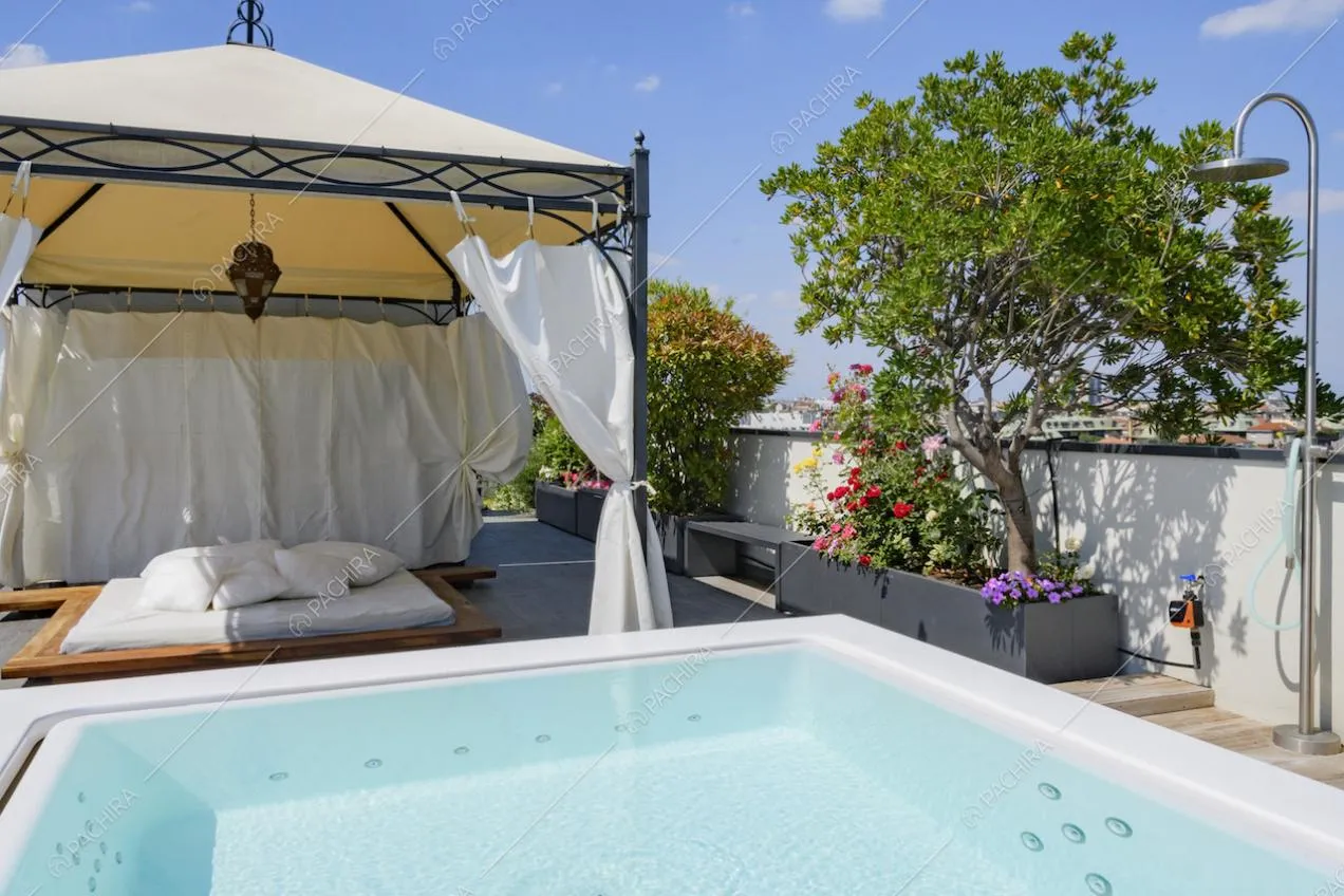 Angolo del terrazzo con piscina, gazebo e letto a terra
