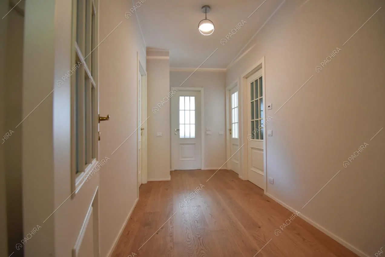 Porte bianche con vetri e parquet nell'androne