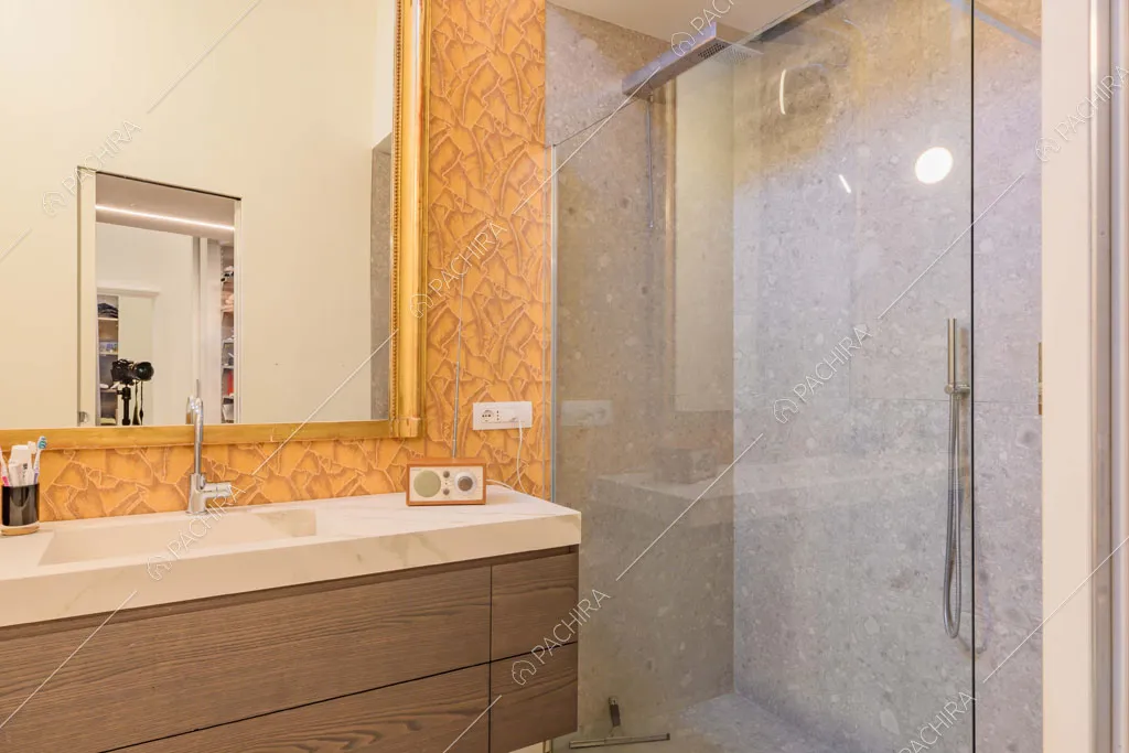 Carta da parati e grande specchio nel bagno con box doccia