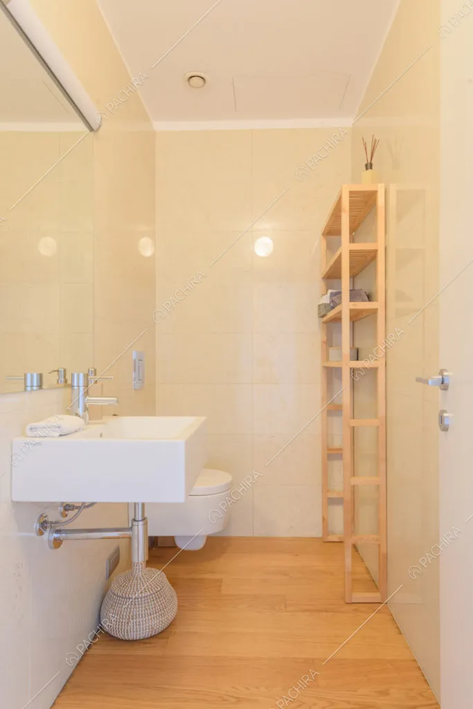 Bagno con pavimento in parquet, pareti gialle e servizi sospesi