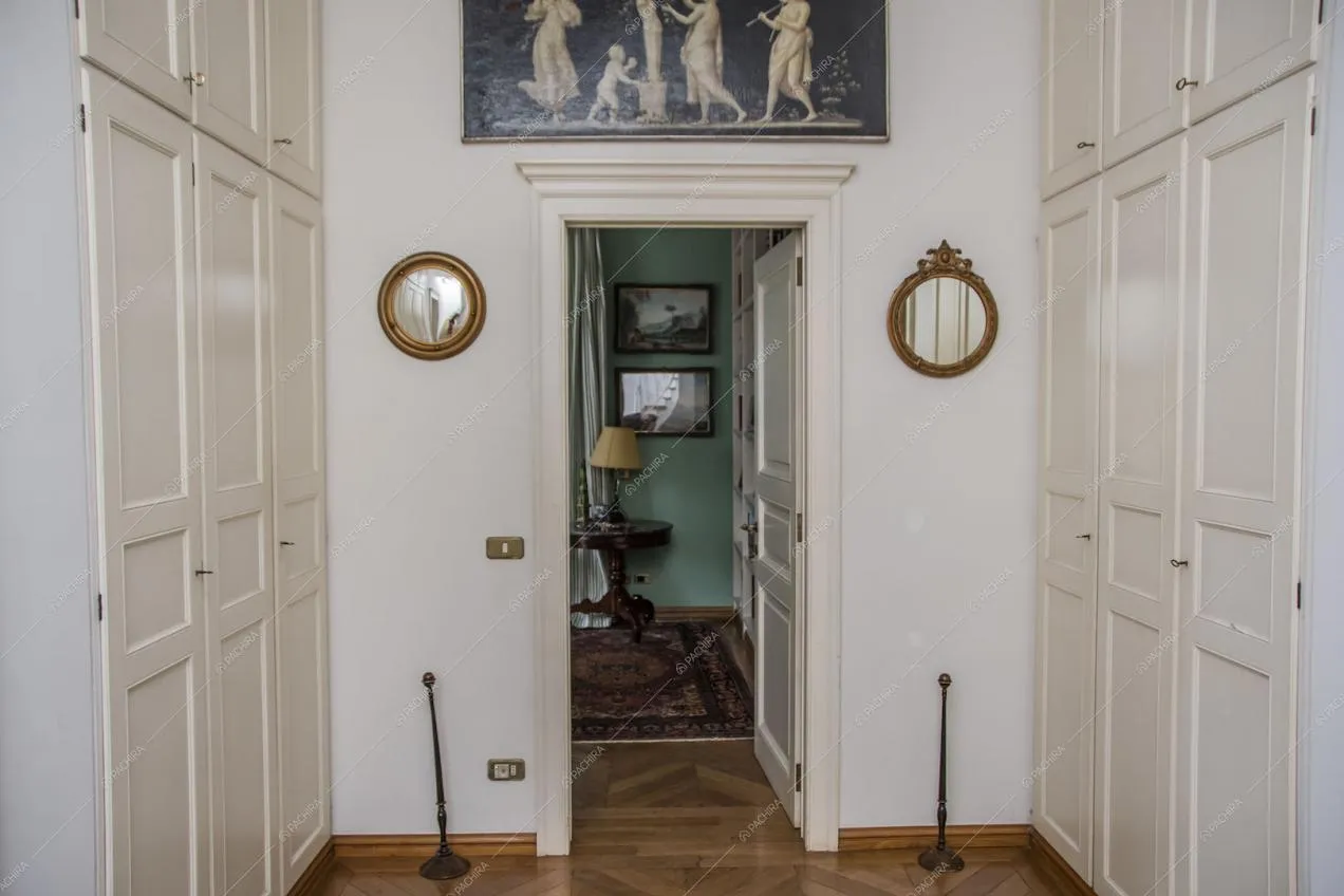 Pavimento in parquet, armadi bianchi a muro e vista sulla stanza