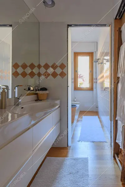 Lungo bagno con grande specchio e pavimento in parquet