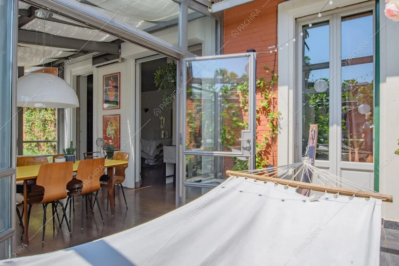 Amaca sulla terrazza con porte-finestre e vista sulla veranda con pavimento in parquet