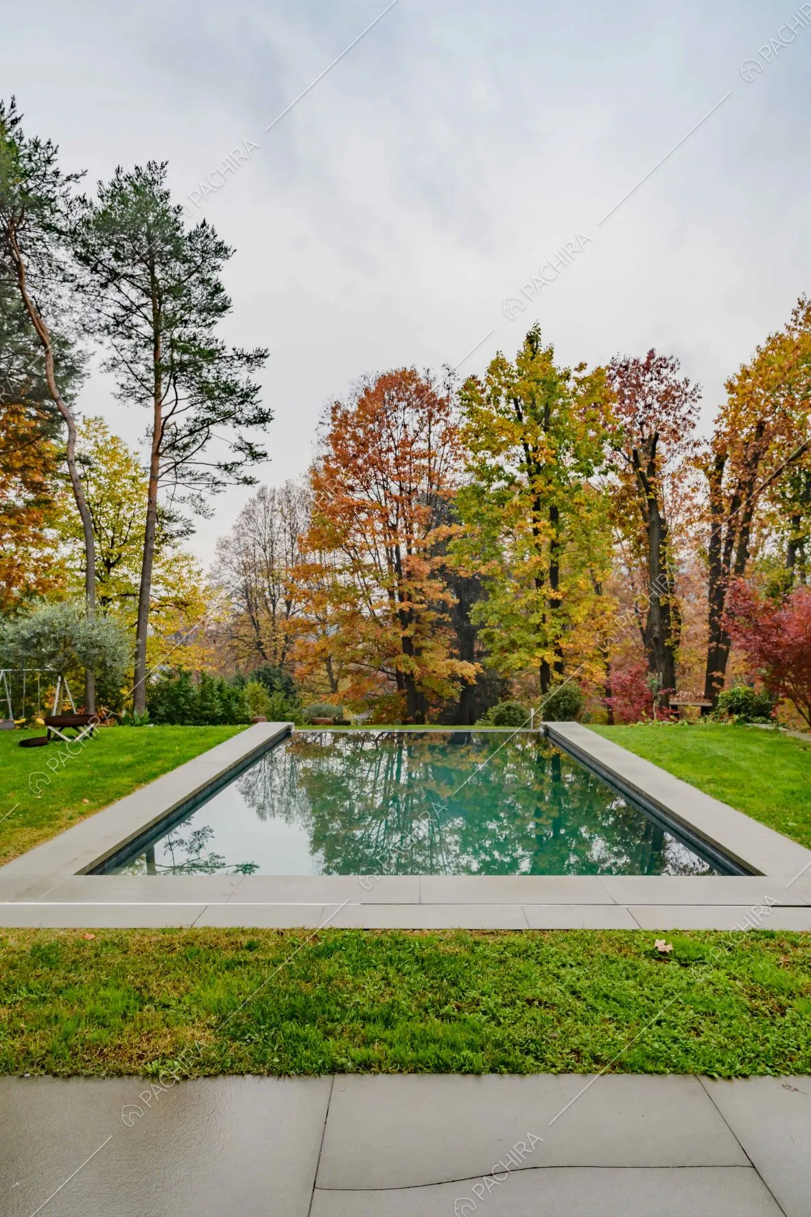 Piscina immersa nel giardino privato con foliage autunnale