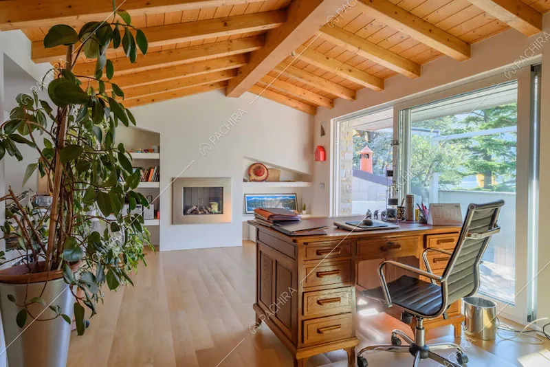 Studio con soffitto in travi in legno a vista e porta-finestra scorrevole