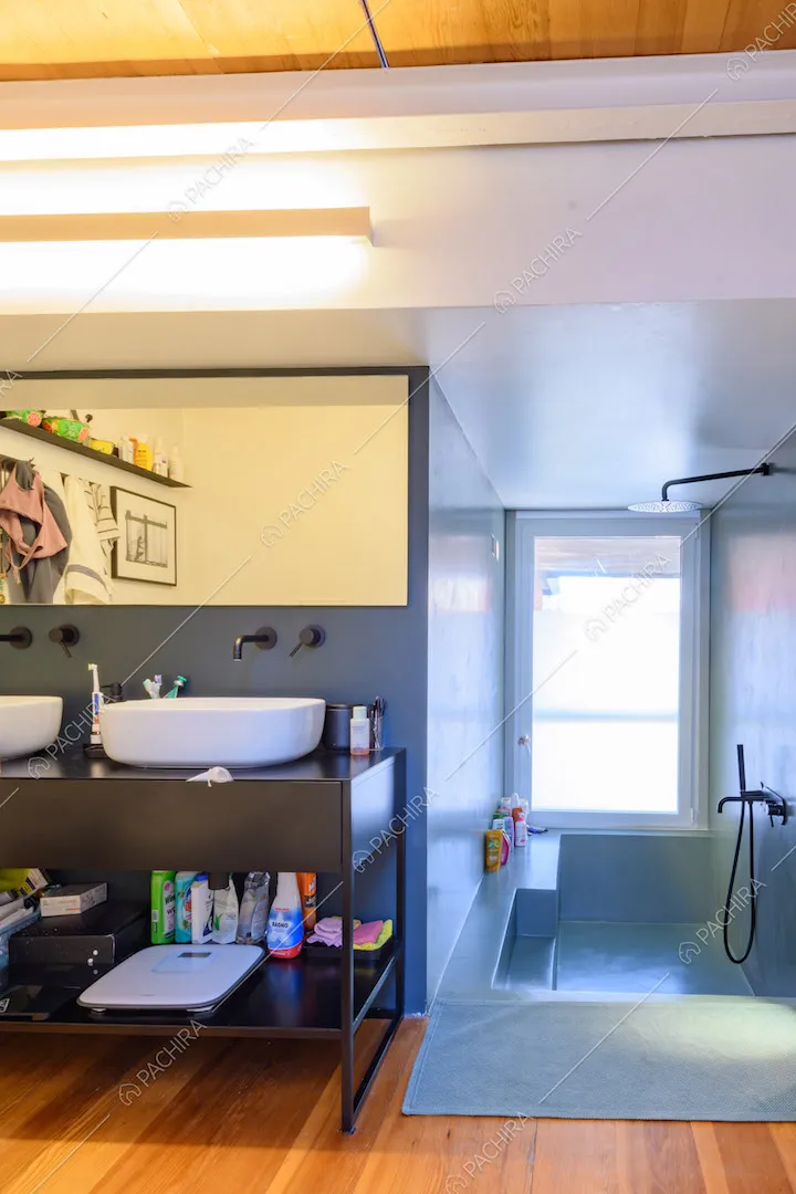 Bagno con pavimento in parquet, doppio lavandino e vasca unita al box doccia