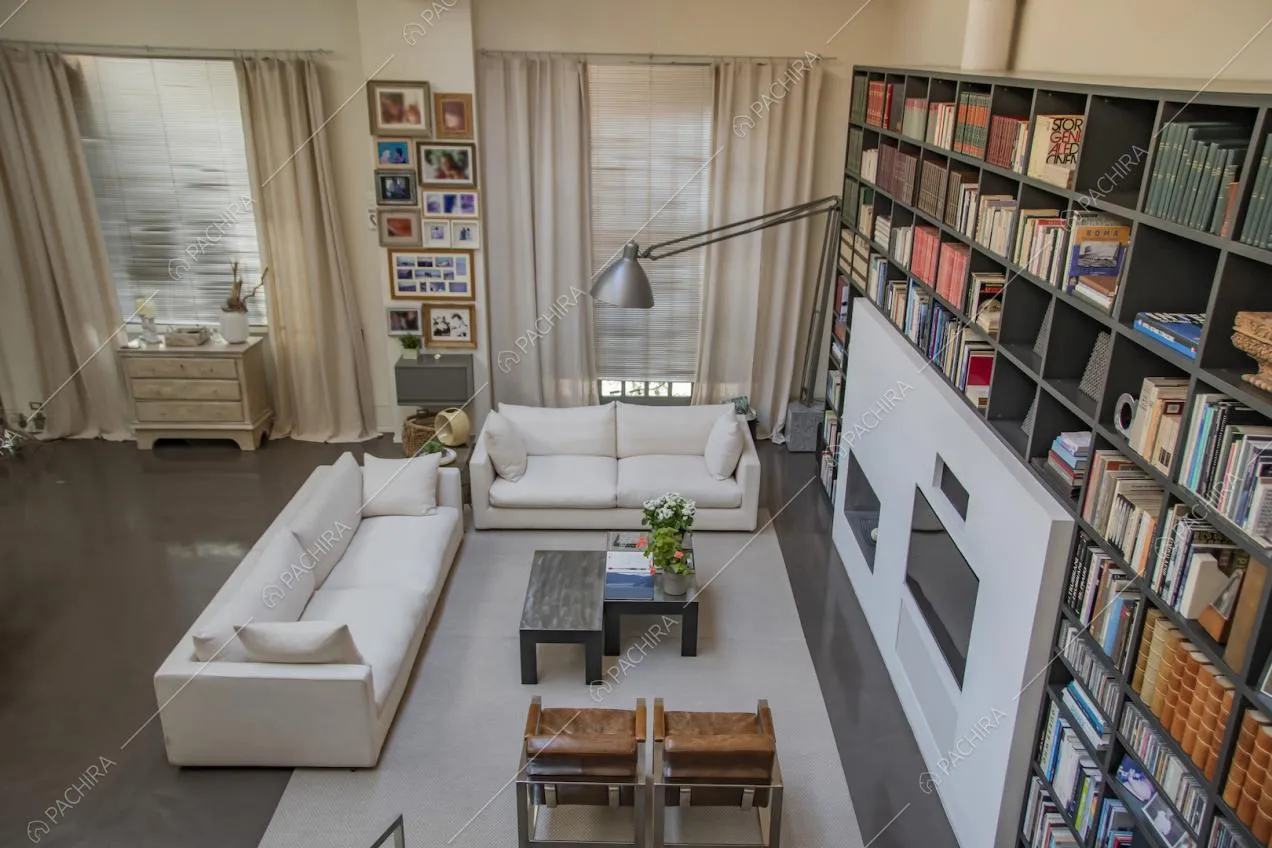 Grande tappeto sotto a divani e poltrone e libreria nell'angolo salotto