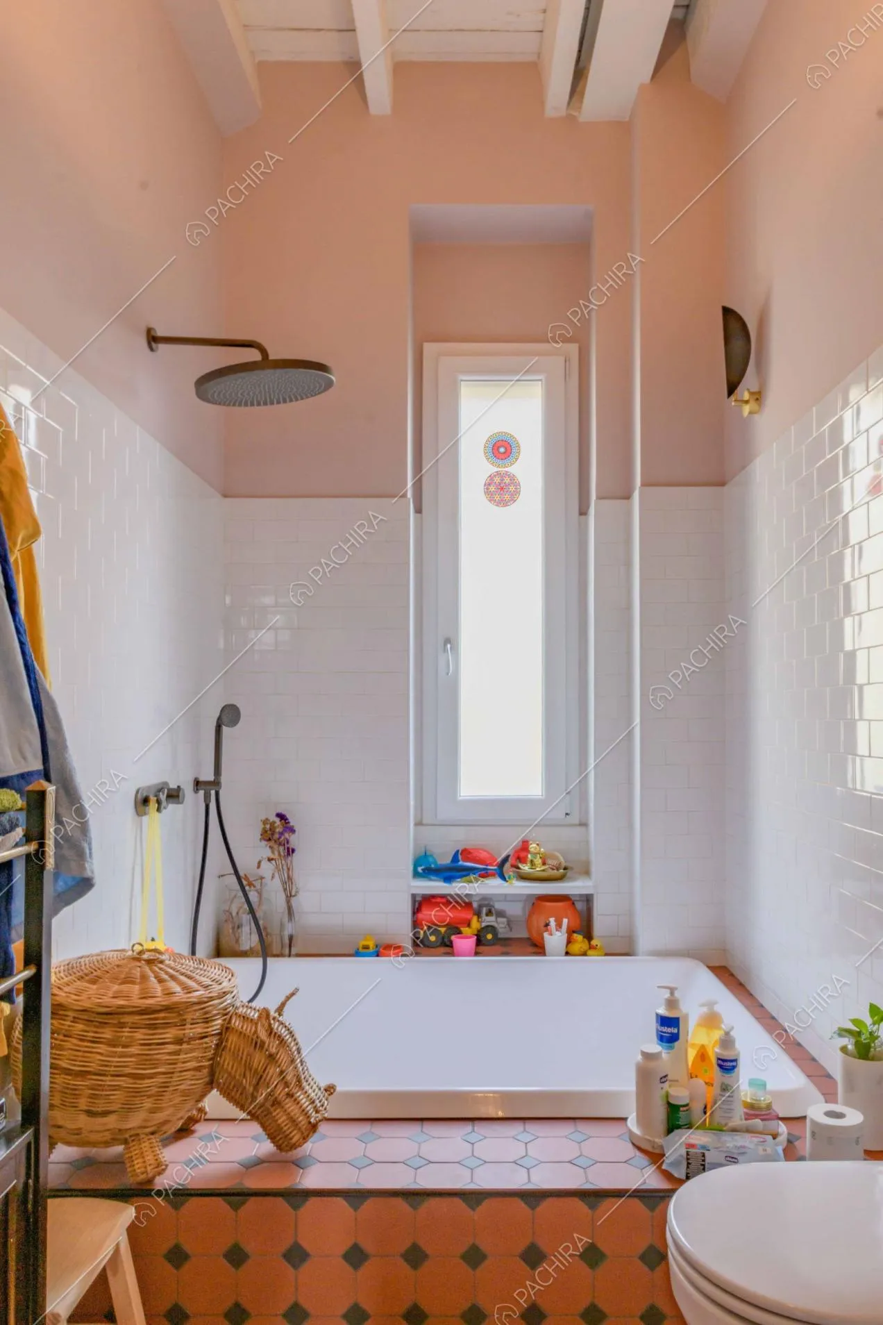 Grande vasca nel bagno principale, con pareti dalle piastrelle bianche