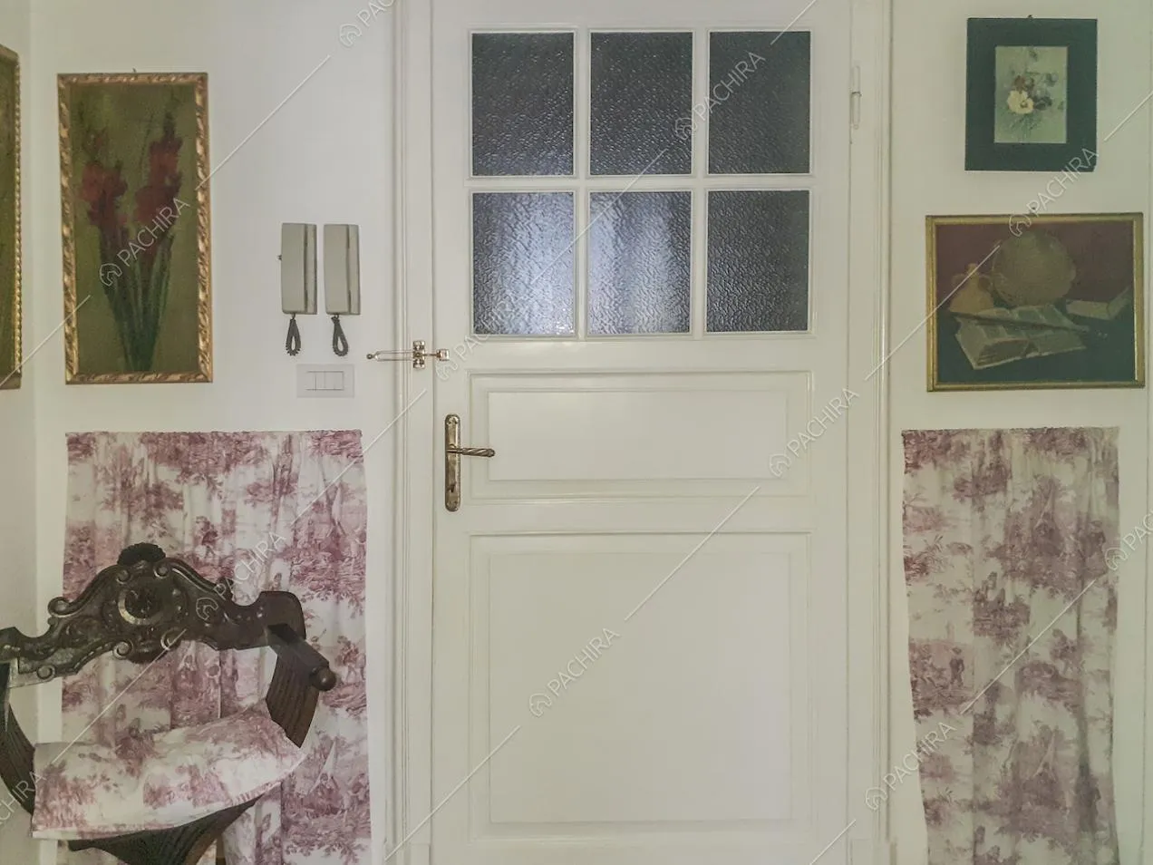 Sedia savonarola in legno lavorato vicino alla porta d'ingresso
