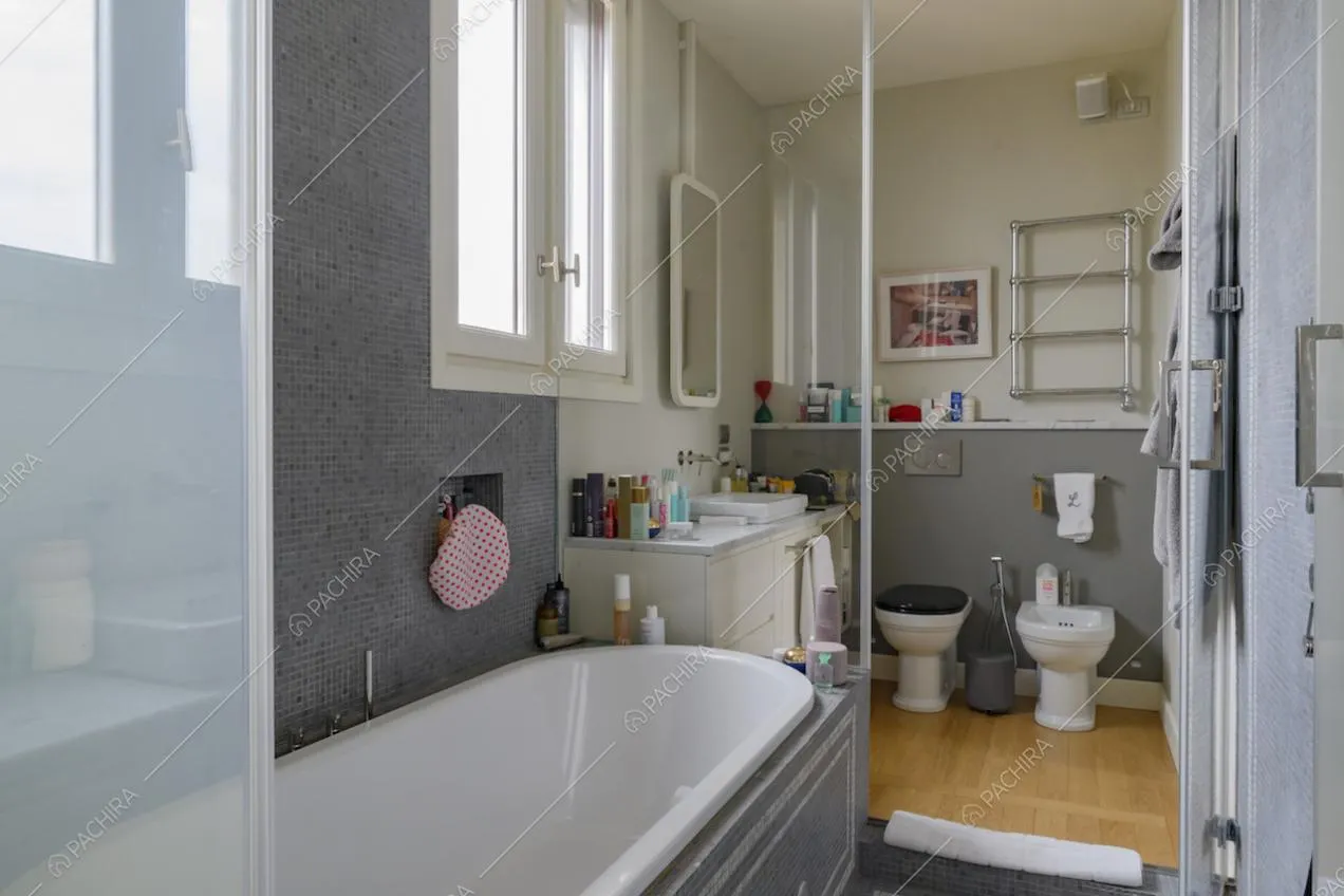Vasca da bagno e doccia in area separata dai sanitari tramite porte in vetro
