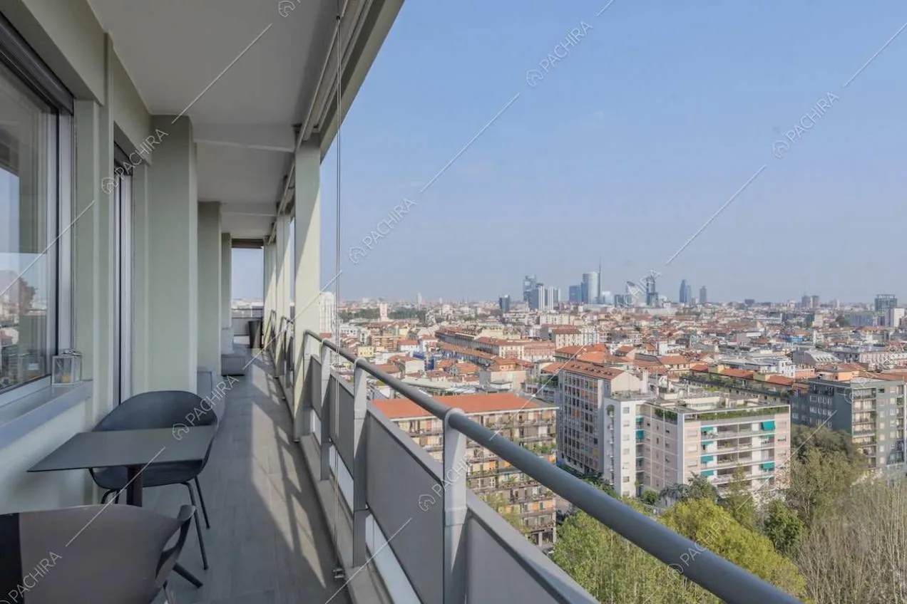 Tavolo da esterni nero sulla terrazza con vista sullo skyline milanese