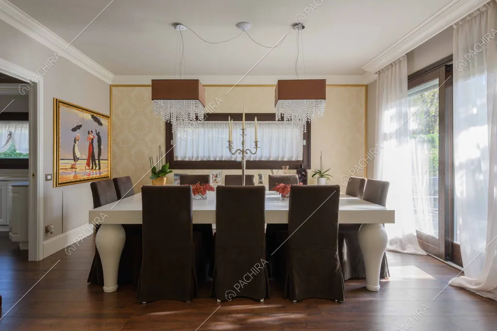 Tavolo da pranzo bianco nella luminosa sala con grandi vetrate e carta da parati