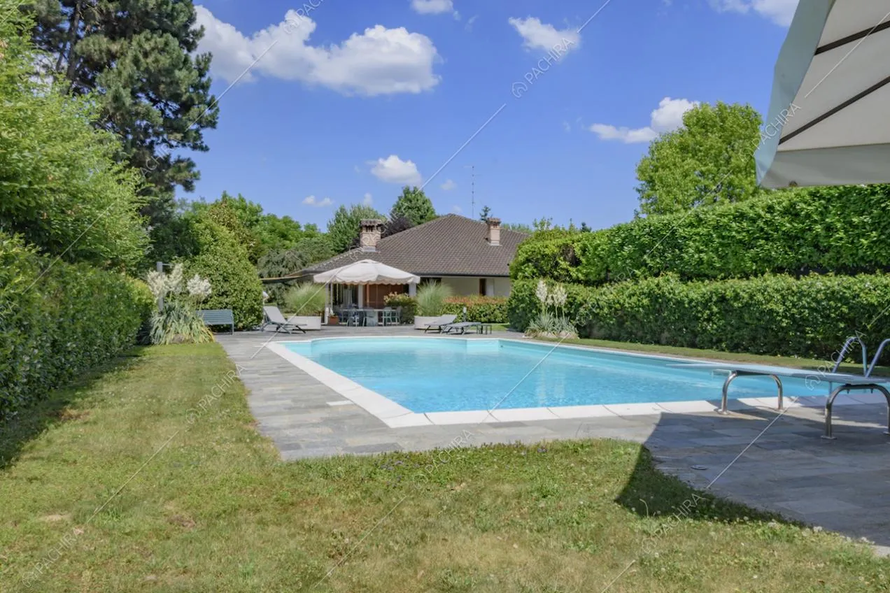 Dal giardino vista sulla piscina, sull'ombrellone da bar e sulla villa