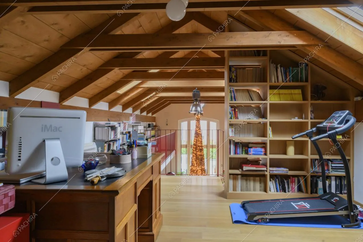 Studio con scrivania in legno, tapis roulant, pavimento in parquet e affaccio sul salone