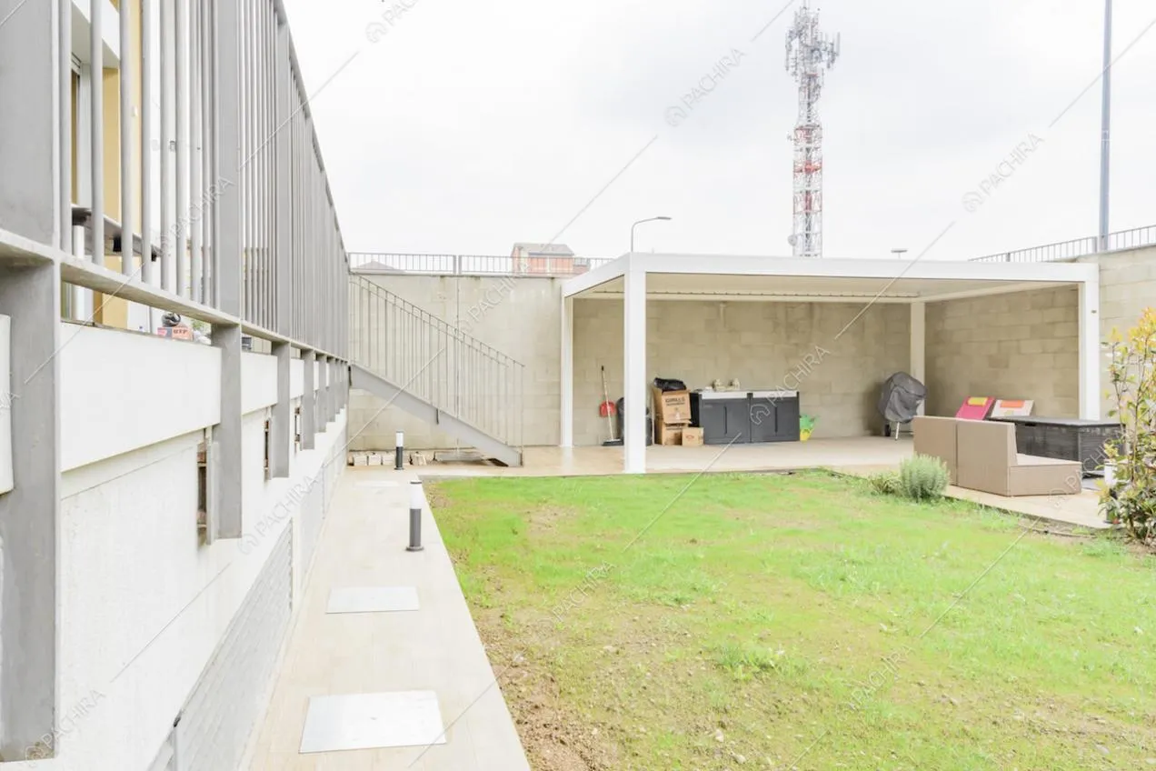 Dal giardino della location vista sulla pergola, sul salotto da esterni e sulle scale