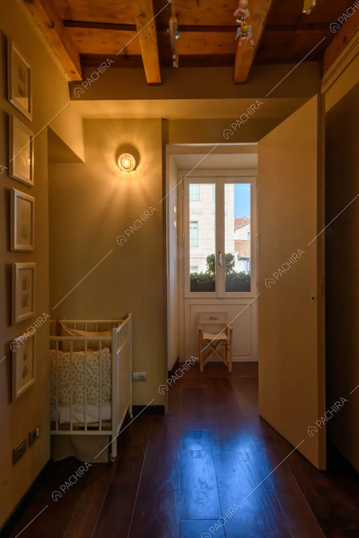 Camera da letto dei bambini con pavimento in parquet e culla